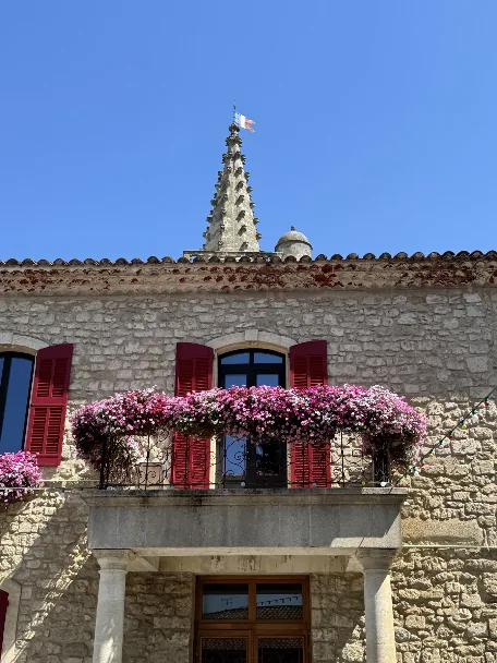 Office de tourisme d’Eyragues avec le clocher de l’église en arrière-plan.