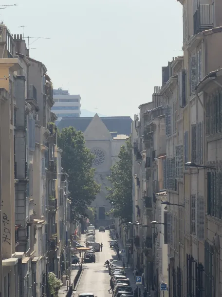 Vue depuis le haut de la rue Terrusse vers l’église Saint-Michel, secteur Camas à Marseille, avec la Carsat en arrière-plan.