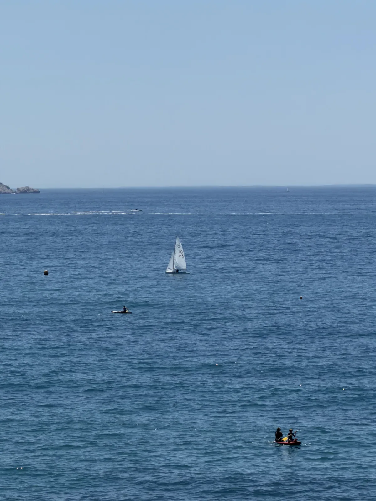 Vue sur la mer depuis la Corniche Kennedy avec voilier et embarcations.