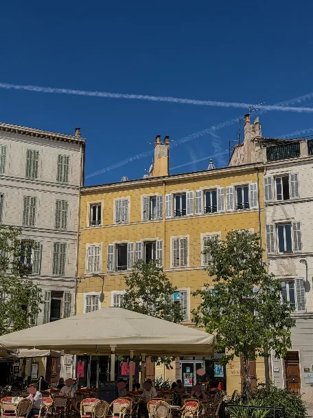 Bâtiment jaune et terrasse près de la place Castellane dans le 6e arrondissement de Marseille.
